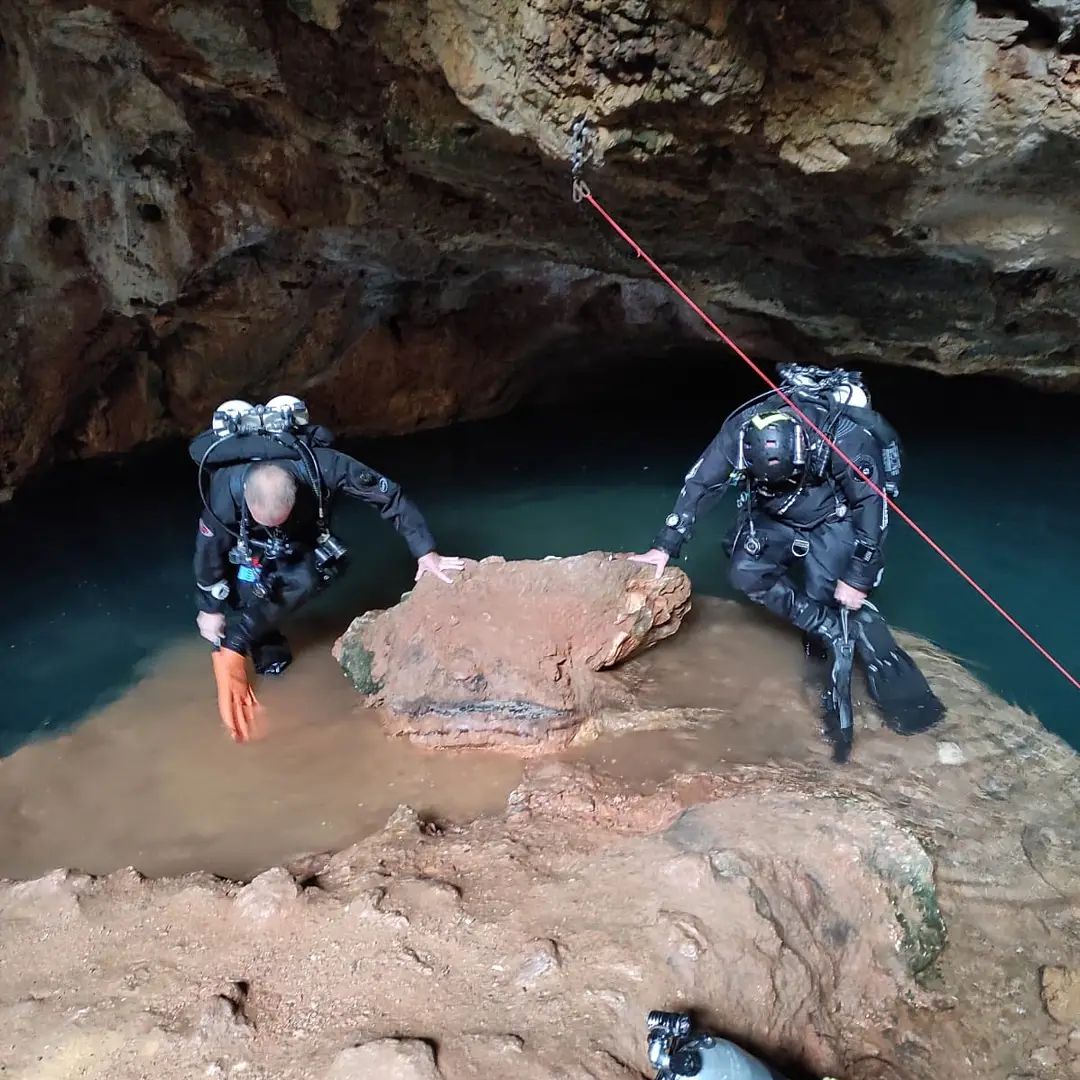 Two divers at cave entry with red guideline